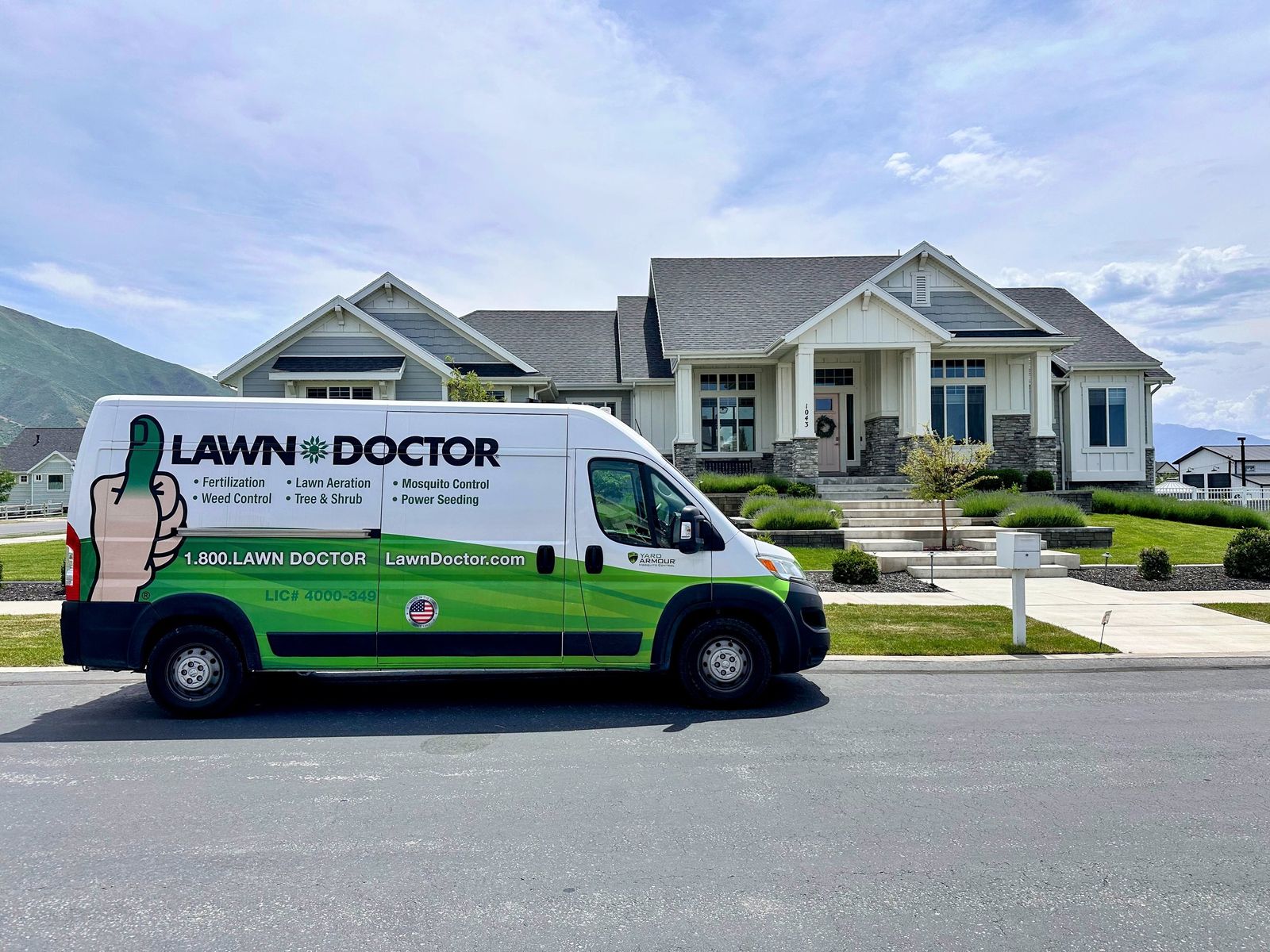 Lawn Doctor technician and service van on a sunny Utah street.